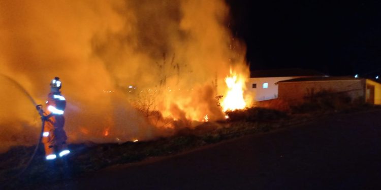 Bombeiros combatem incêndio em vegetação que ameaçava atingir residências na cidade de Ouro Branco