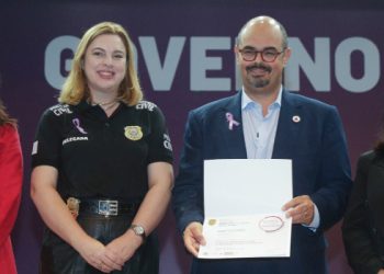 O Governo de Minas continua intensificando suas ações no combate à violência contra as mulheres em todo o estado e instituiu, nesta quarta-feira (21/8), a criação da Diretoria Estadual de Gestão das Delegacias de Atendimento à Mulher.  Essa nova divisão será responsável por coordenar a política de prevenção e enfrentamento da violência doméstica e familiar contra as mulheres.  A diretoria terá a função de supervisionar tecnicamente as ações de todas as delegacias especializadas em atendimento às mulheres em Minas Gerais. O objetivo é unificar o tratamento dos casos e aprimorar a coordenação das informações e estratégias entre as diferentes unidades policiais.  A assinatura do despacho que determina a criação do órgão foi feita pelo vice-governador de Minas Gerais, Professor Mateus, durante o evento “Agosto Lilás: Quebre o Ciclo da Violência”, realizado no Auditório JK, na Cidade Administrativa, em Belo Horizonte.  O evento é realizado pela Polícia Civil de Minas Gerais (PCMG) e pela Secretaria de Estado de Desenvolvimento Social (Sedese-MG), com apoio da Secretaria de Estado de Governo (Segov).  O vice-governador de Minas destacou que o momento é de sensibilização, revisão de resultados e planejamento das ações a serem executadas para combater a violência contra as mulheres no estado.  “Esse esforço envolve várias áreas do nosso governo. Ao longo dos últimos três anos e meio, o governador tem enfatizado a necessidade de programas e estruturas dedicadas a esse combate, o que resultou em uma expansão considerável das delegacias de atendimento às mulheres em todo o estado e, agora, na criação de uma diretoria para coordenar essas delegacias”, destacou o vice-governador.