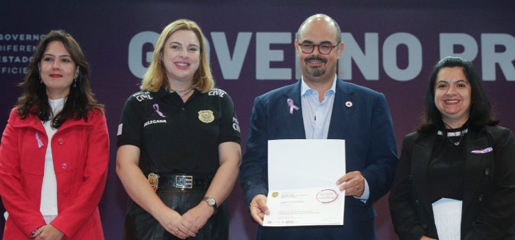 O Governo de Minas continua intensificando suas ações no combate à violência contra as mulheres em todo o estado e instituiu, nesta quarta-feira (21/8), a criação da Diretoria Estadual de Gestão das Delegacias de Atendimento à Mulher. Essa nova divisão será responsável por coordenar a política de prevenção e enfrentamento da violência doméstica e familiar contra as mulheres. A diretoria terá a função de supervisionar tecnicamente as ações de todas as delegacias especializadas em atendimento às mulheres em Minas Gerais. O objetivo é unificar o tratamento dos casos e aprimorar a coordenação das informações e estratégias entre as diferentes unidades policiais. A assinatura do despacho que determina a criação do órgão foi feita pelo vice-governador de Minas Gerais, Professor Mateus, durante o evento “Agosto Lilás: Quebre o Ciclo da Violência”, realizado no Auditório JK, na Cidade Administrativa, em Belo Horizonte. O evento é realizado pela Polícia Civil de Minas Gerais (PCMG) e pela Secretaria de Estado de Desenvolvimento Social (Sedese-MG), com apoio da Secretaria de Estado de Governo (Segov). O vice-governador de Minas destacou que o momento é de sensibilização, revisão de resultados e planejamento das ações a serem executadas para combater a violência contra as mulheres no estado. “Esse esforço envolve várias áreas do nosso governo. Ao longo dos últimos três anos e meio, o governador tem enfatizado a necessidade de programas e estruturas dedicadas a esse combate, o que resultou em uma expansão considerável das delegacias de atendimento às mulheres em todo o estado e, agora, na criação de uma diretoria para coordenar essas delegacias”, destacou o vice-governador.